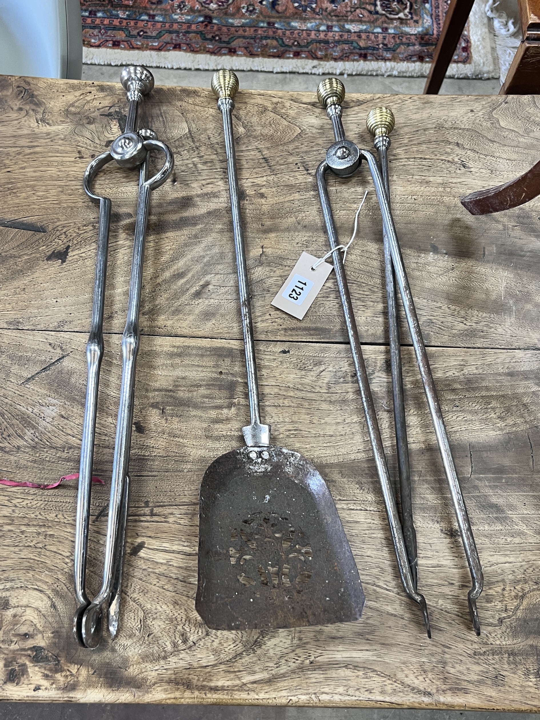 A set of three brass mounted steel fire implements together with a pair of tongs and a poker